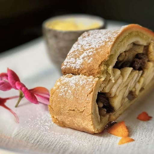 Apfelstrudel mit Vanillesauce und einer Blüte