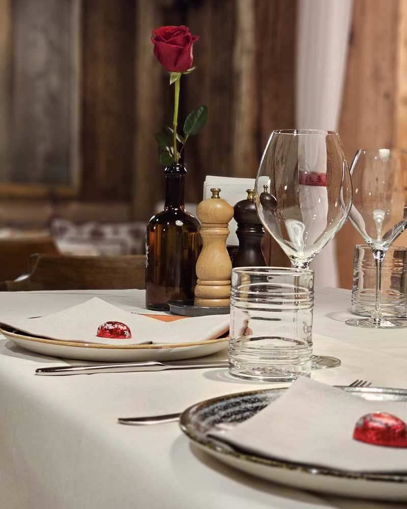 Elegant gedeckter Tisch mit roter Rose und Weingläsern